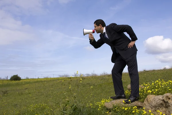 Businessman speaking with a megaphone — Stock Photo, Image
