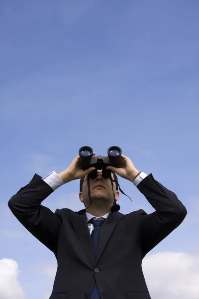 Affärsman som tittar genom kikare — Stockfoto