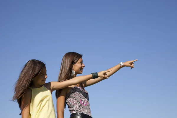 Happy sisters pointing away — Stock Photo, Image