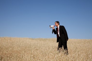 Businessman shouting at the megaphone to you clipart