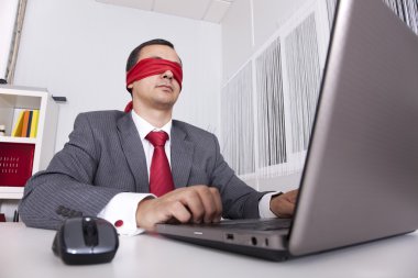 Blindfold businessman working with his laptop clipart