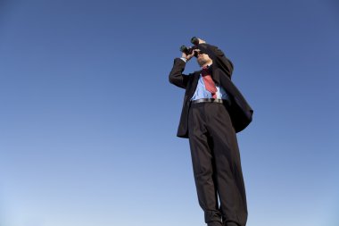 Businessman searching with his binoculars clipart