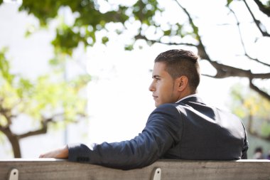 Businessman sit in the bench park clipart