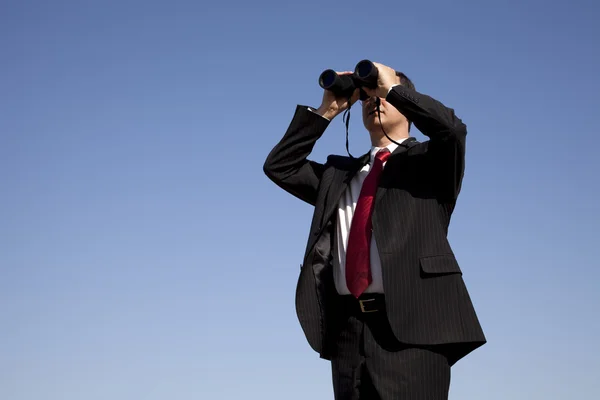 Empresário olhando através de binóculos — Fotografia de Stock