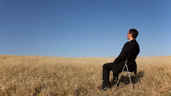 Üzletember várja a mező — Stock Fotó