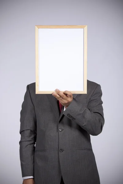 Empresário segurando um quadro branco — Fotografia de Stock
