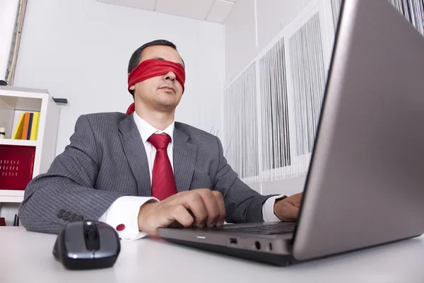 Blinddoek zakenman werken met zijn laptop — Stockfoto