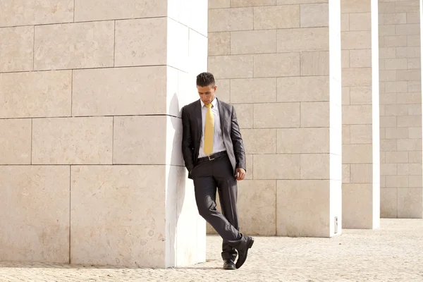 Triste homme d'affaires relaxant à côté d'un mur — Photo