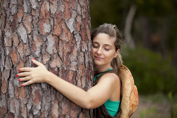 Молодая женщина обнимает дерево — стоковое фото