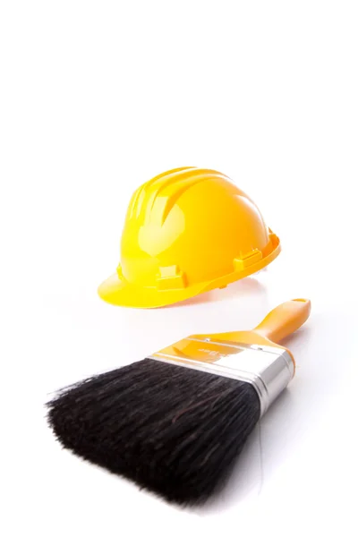 Construction helmet and a paint brush — Stock Photo, Image