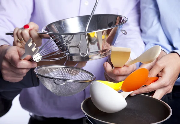 Mãos segurando utensílios de cozinha — Fotografia de Stock