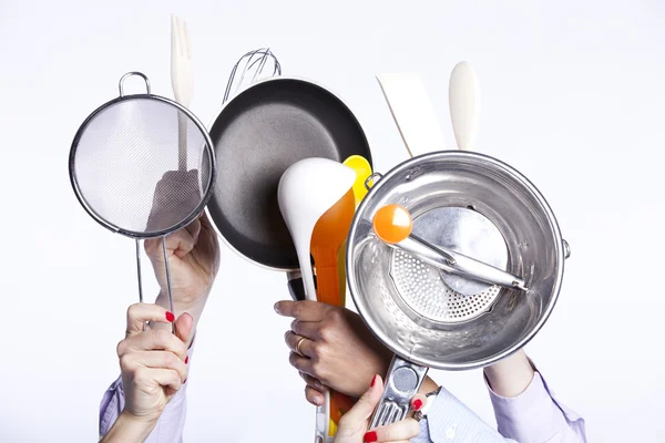 Mãos segurando utensílios de cozinha — Fotografia de Stock