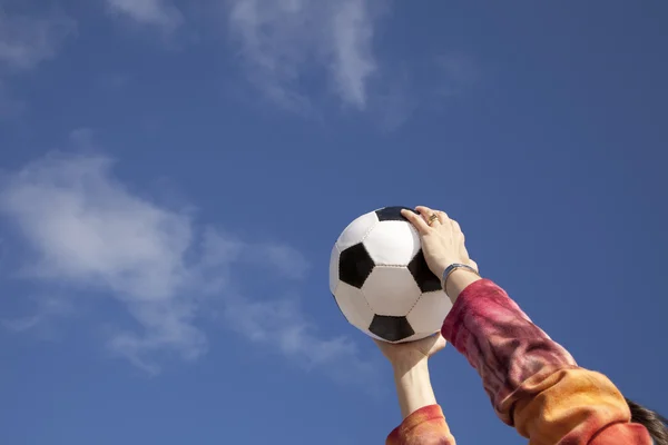 Руки держат футбольный мяч — стоковое фото