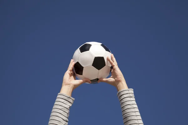 Mani che tengono un pallone da calcio — Foto Stock