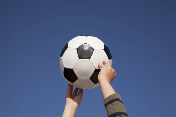 Mani che tengono un pallone da calcio — Foto Stock