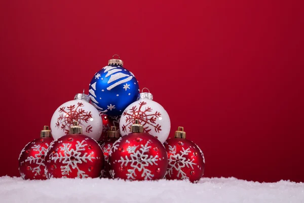 Weihnachtskugeln vor rotem Hintergrund — Stockfoto