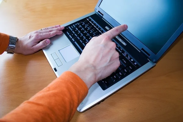 Jovem apontando para laptop — Fotografia de Stock