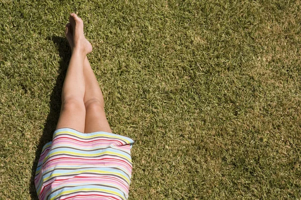 Pernas de mulher na grama — Fotografia de Stock