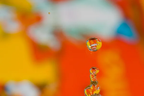 Een vloeibare vorm van water met een achtergrond in kleur — Stockfoto