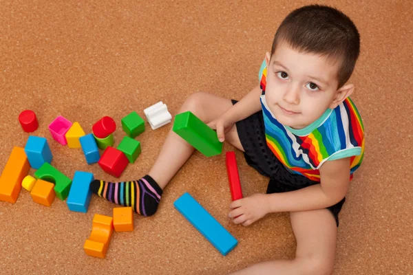 Menino jogando blocos de brinquedo vívidos — Fotografia de Stock