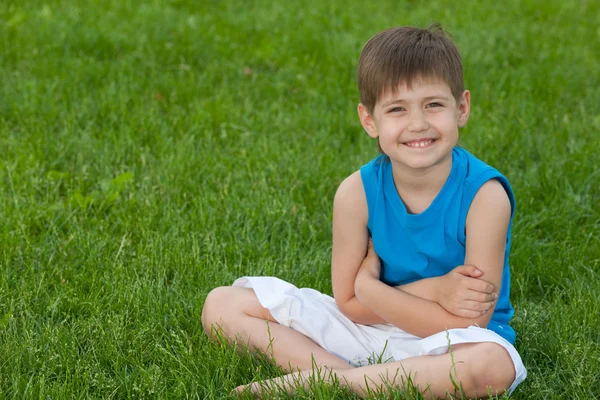 Веселый мальчик на лужайке — стоковое фото
