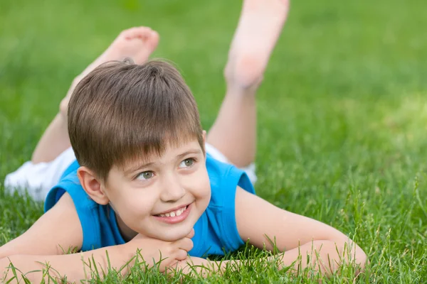 Veselý kluk na zeleném trávníku — Stock fotografie