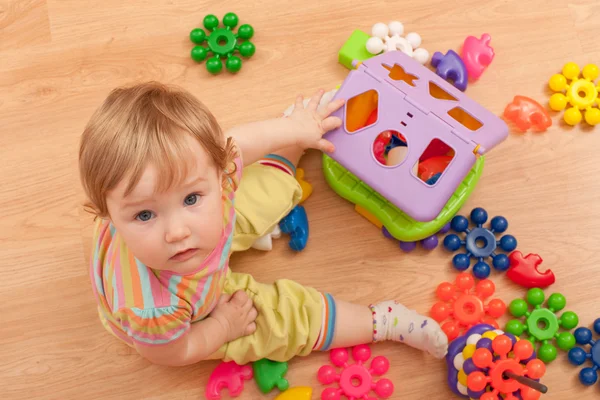 Criança entre brinquedos — Fotografia de Stock