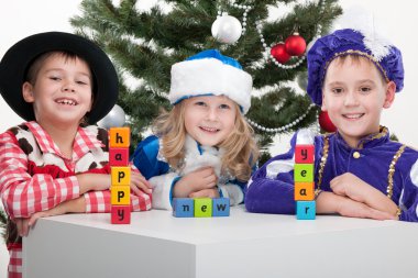 Three children dressed in carnival suits are greeting with sigh 