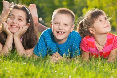 çimenlerin üzerinde üç mutlu çocuk