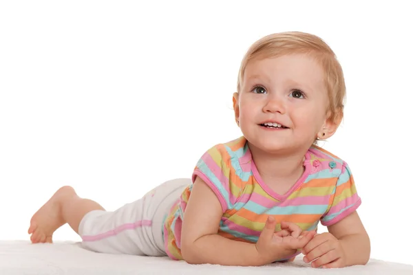 Allegro bambina sdraiata sul bianco guardando in alto — Foto Stock