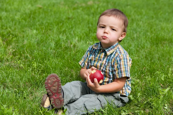 Kleine jongen eten apple buiten — Stockfoto