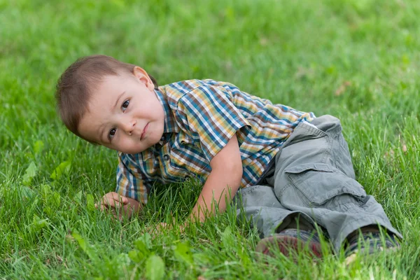 Huelga silenciosa de un niño contra la hierba verde —  Fotos de Stock