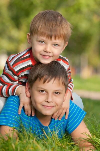 Два улыбающихся брата на траве — стоковое фото