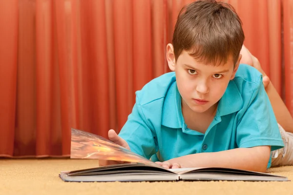 Ernstige knappe jongen met een boek — Stockfoto