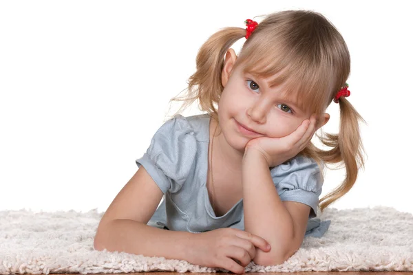 思いやりのある女の子の毛足の長いカーペットの上に横たわる — ストック写真