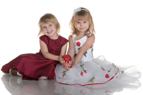 Two smiling girls holding a red apple — Stock Photo, Image
