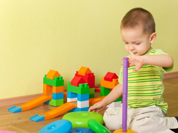 Kid bouwen een speelgoed piramide — Stockfoto