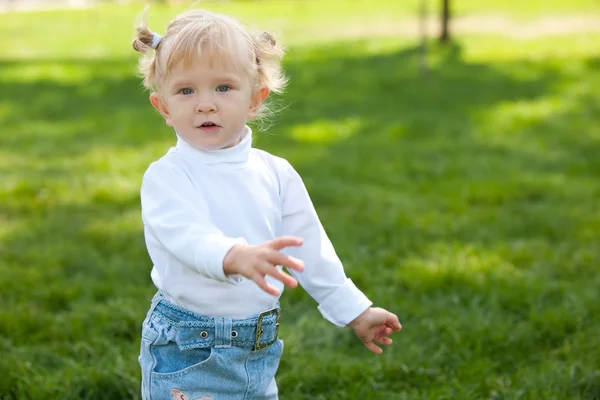 Lekfull blond liten flicka promenader i parken — Stockfoto
