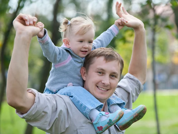 Toddler riding her dad in the park — Stock Photo, Image