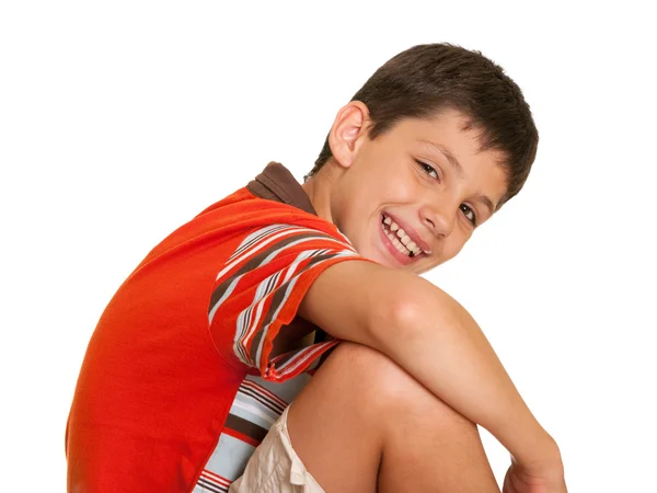 Сидящий улыбающийся ребенок — стоковое фото