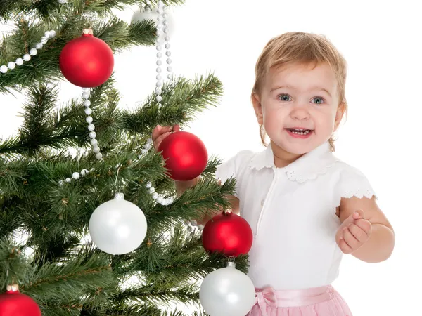 Ευτυχισμένο κοριτσάκι που στολίζει ένα χριστουγεννιάτικο δέντρο — Φωτογραφία Αρχείου