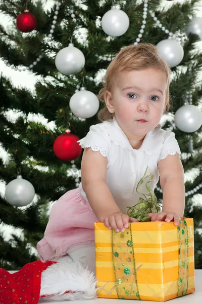 Peuter ontdekken een kerstcadeau op een nieuwe jaar boom — Stockfoto