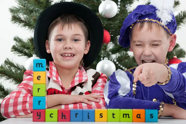Two boys greet with merry christmas at the christmas masket ball — Stock Photo, Image