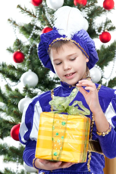 Niño en traje de carnaval príncipe abriendo regalo de Navidad —  Fotos de Stock