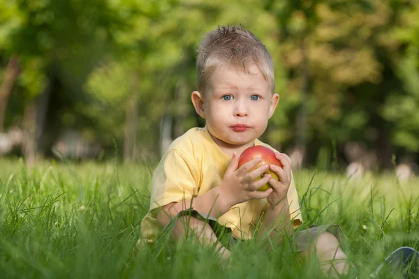 Pensativo chico de la moda con una manzana — Foto de Stock