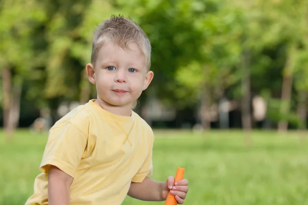 Niño reflexivo con una zanahoria — Foto de Stock