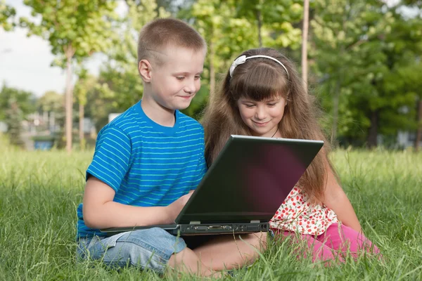 Met een laptop op het gras — Stockfoto