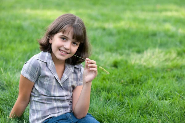 Retrato de una chica bonita con una brizna de hierba — Foto de Stock