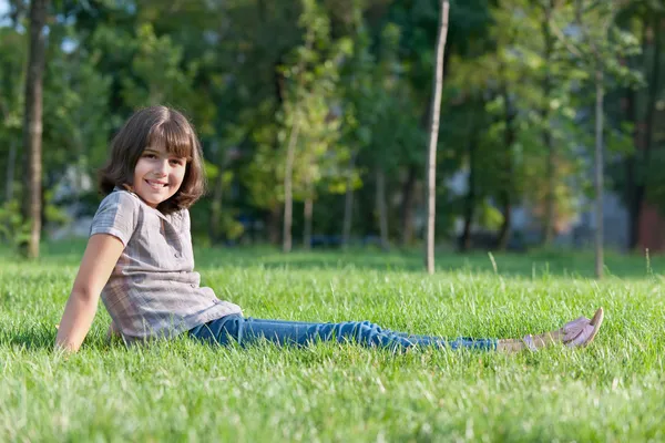 Veselá dívka, spočívající v parku — Stock fotografie