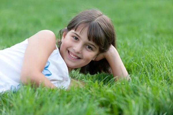 Portret zbliżenie ładny dziewczyna leży w parku lato — Zdjęcie stockowe